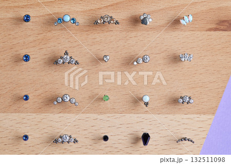 Beautiful piercing jewelry on wooden display. Macro shot. Selective focus. 132511098