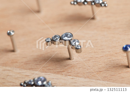 Beautiful piercing jewelry on wooden display. Macro shot. Selective focus. 132511113