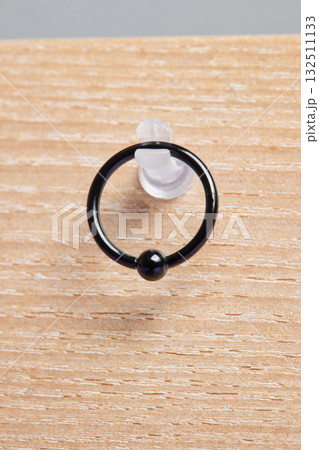 Beautiful piercing jewelry on wooden display. Macro shot. Selective focus. 132511133