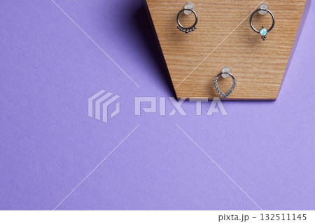 Beautiful piercing jewelry on wooden display. Macro shot. Selective focus. 132511145