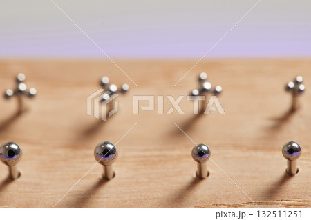 Beautiful piercing jewelry on wooden display. Macro shot. Selective focus. 132511251