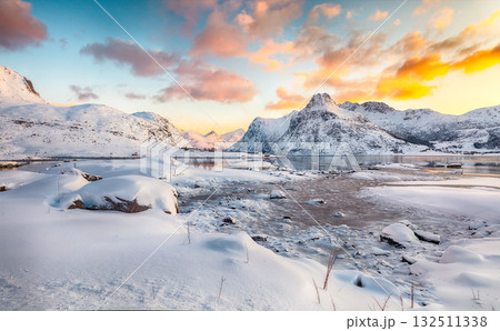 Amazing Flakstadpollen and Boosen fjords with cracks on ice during sunrise with Hustinden mountain on background. Amazing Flakstadpollen and Boosen fjords with cracks on ice during sunrise with Hustinden mountain on background. 132511338