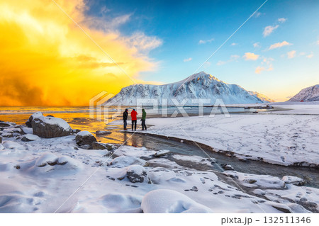 Group of tourist looking  on Skagsanden beach with illuminated clouds during sunrise 132511346