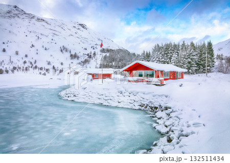 Amazing winter scenery with traditional Norwegian red wooden houses on the shore of Rolvsfjord. Amazing winter scenery with traditional Norwegian red wooden houses on the shore of Rolvsfjord. 132511434