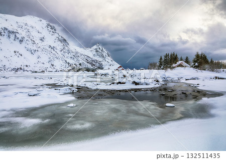 Amazing winter scenery with snowy  mountain peaks  on the shore of Rolvsfjord on Vestvagoy island at Lofotens. 132511435