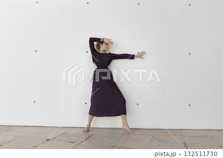 Woman dancing against wall expressing freedom and movement 132511730
