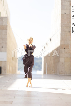 Woman dancing barefoot performing expressive movement Woman dancing barefoot performing expressive movement 132511748