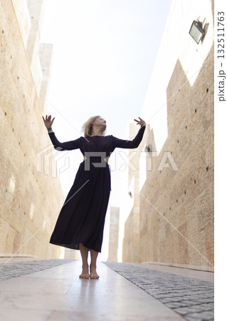 Woman dancing barefoot feeling freedom in urban passage Woman dancing barefoot feeling freedom in urban passage 132511763