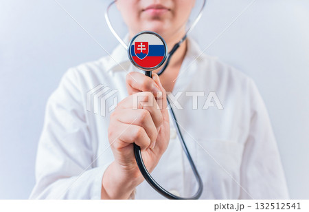 Female doctor holding stethoscope with Slovakian flag. National health system of Slovakia 132512541