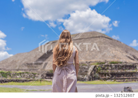 Female tourist standing in front of Teotihuacan pyramids in Mexico, enjoying sightseeing, adventure, and cultural heritage. Travel, tourism, and exploration concept 132512607