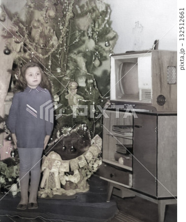 Vintage portrait of a cute little girl by the Christmas tree. Retro photo from 1973. Vintage portrait of a cute little girl by the Christmas tree. Retro photo from 1973. 132512661
