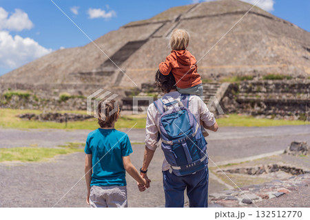 Father with his two sons as tourists in front of the pyramids of Teotihuacan, Mexico, enjoying family travel, sightseeing, and cultural heritage together 132512770