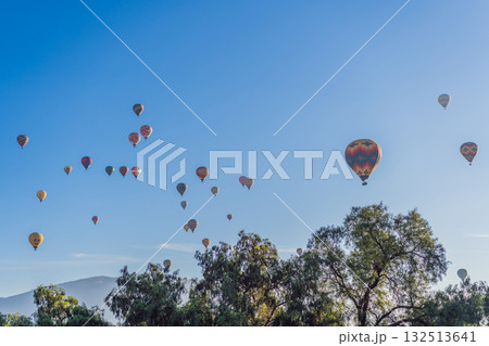 Colorful hot air balloons floating over Teotihuacan in Mexico, creating a breathtaking view of the ancient pyramids. Tourism, adventure, and cultural heritage concept Colorful hot air balloons floating over Teotihuacan in Mexico, creating a breathtaking view of the ancient pyramids. Tourism, adventure, and cultural heritage concept 132513641