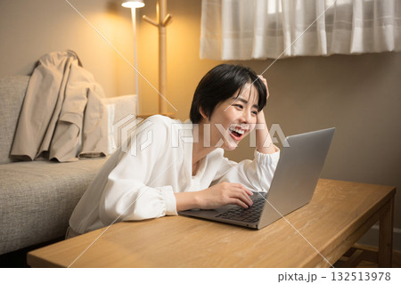 仕事が終わらなくて結局家で仕事する女性 夜の部屋でパソコンを見て頭を抱える女性 仕事が終わらなくて結局家で仕事する女性 夜の部屋でパソコンを見て頭を抱える女性 132513978