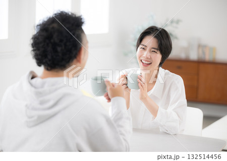 リビングでコーヒーや飲み物を飲みながらくつろぐ夫婦 132514456