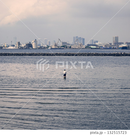 海に入って釣りをする人の後ろ姿 132515723