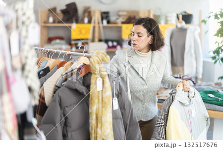 woman chooses outerwear at a sale in a showroom 132517676