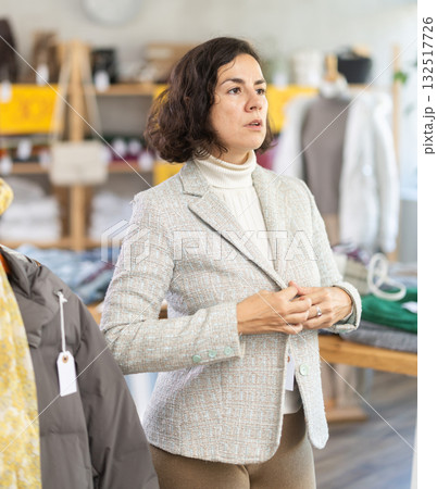 Latin American woman is fitting on and trying on blazer in store Latin American woman is fitting on and trying on blazer in store 132517726