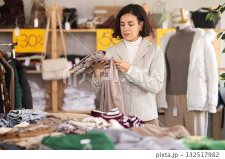 Woman at the counter in the store choosing pants Woman at the counter in the store choosing pants 132517982