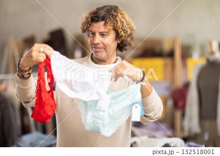 man chooses panties in a clothing store for his wife 132518001