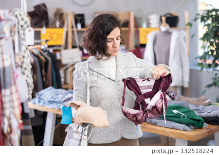 Adult woman choosing bras in store Adult woman choosing bras in store 132518224