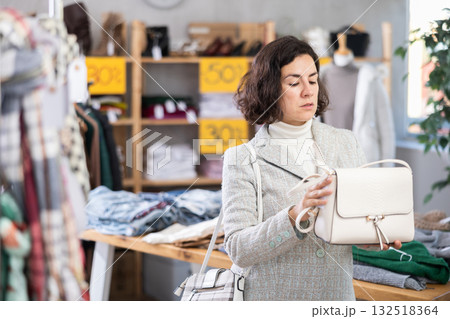 Latin American woman search and choose leather bag in shop 132518364