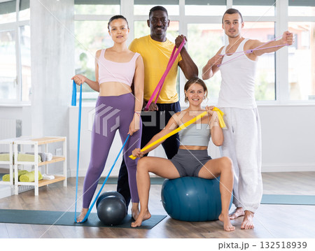 Multiethnic group of cheerful sporty people with fitness equipment in studio Multiethnic group of cheerful sporty people with fitness equipment in studio 132518939
