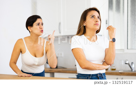 Woman listening her girlfriend standing behind and quarreling with her 132519117