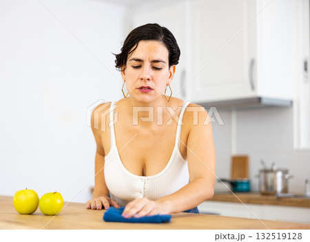 Latin american woman cleaning kitchen countertop with rag and spray 132519128