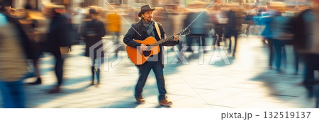 Country musician playing acoustic guitar and singing in a crowded city center with blurred people walking by, creating a sense of motion and urban atmosphere 132519137