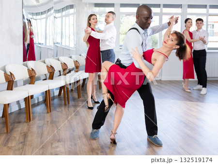 African man and woman dancing tango in couple during lesson at studio African man and woman dancing tango in couple during lesson at studio 132519174