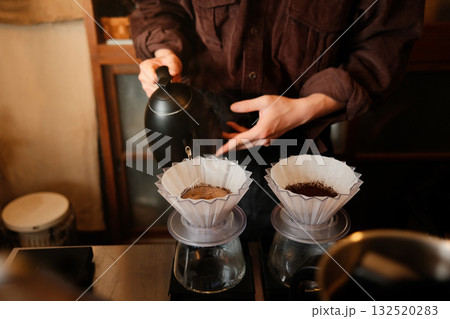 Barista carefully making pour-over coffee in cafe 132520283