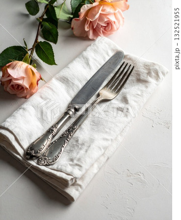 リネンのナプキンの上に置かれたアンティークなフォークとナイフ 132521955