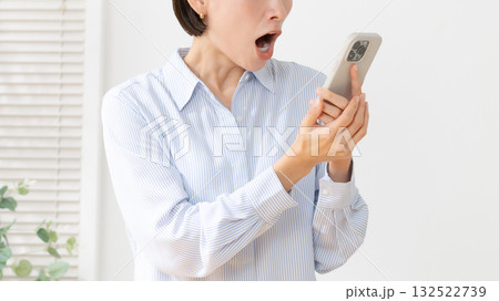 スマホを持って驚く女性 132522739