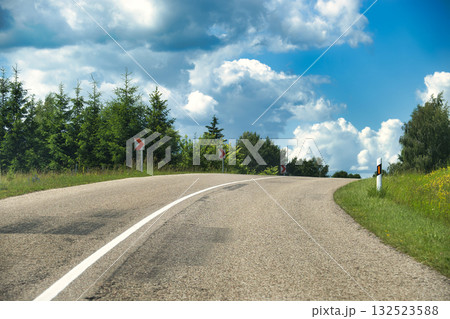 Curving Country Road Winding Through Green Trees Under a Bright Sky On a Sunny Day Curving Country Road Winding Through Green Trees Under a Bright Sky On a Sunny Day 132523588