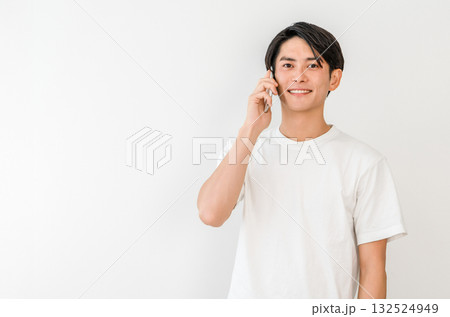 スマホで電話する若いアジア人男性（家,笑顔） 132524949