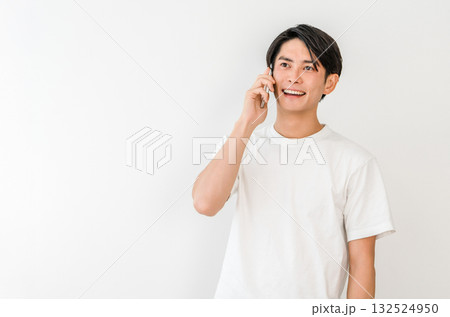 スマホで電話する若いアジア人男性（家,笑顔） 132524950