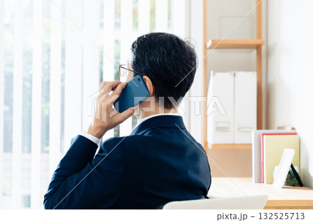 スマホで通話する中高年のビジネスマン スマホで通話する中高年のビジネスマン 132525713