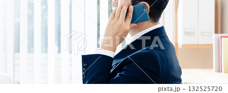 スマホで通話する中高年のビジネスマン スマホで通話する中高年のビジネスマン 132525720