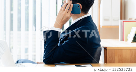 スマホで通話する中高年のビジネスマン スマホで通話する中高年のビジネスマン 132525722