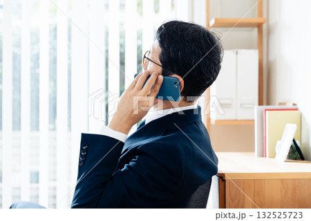 スマホで通話する中高年のビジネスマン 132525723