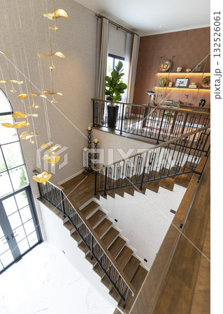 Home entrance hallway with modern chandelier and stairway leading to second floor. 132526061