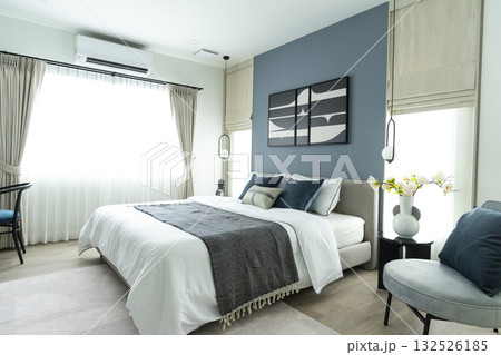 Stylish Bedroom in blue and white tone pillows setting. Cozy bedroom with art wall. Stylish Bedroom in blue and white tone pillows setting. Cozy bedroom with art wall. 132526185