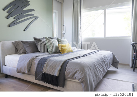 Stylish Bedroom in blue and white tone pillows setting. Cozy bedroom with art wall. Stylish Bedroom in blue and white tone pillows setting. Cozy bedroom with art wall. 132526191
