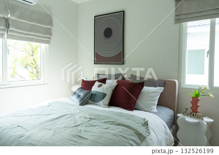 Stylish Bedroom in blue and white tone pillows setting. Cozy bedroom with art wall. Stylish Bedroom in blue and white tone pillows setting. Cozy bedroom with art wall. 132526199