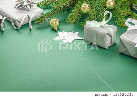 Silver gift boxes with mint ribbons and fir branches on green background, festive Christmas composition with copy space for greeting or holiday message, elegant winter flat lay Silver gift boxes with mint ribbons and fir branches on green background, festive Christmas composition with copy space for greeting or holiday message, elegant winter flat lay 132526233