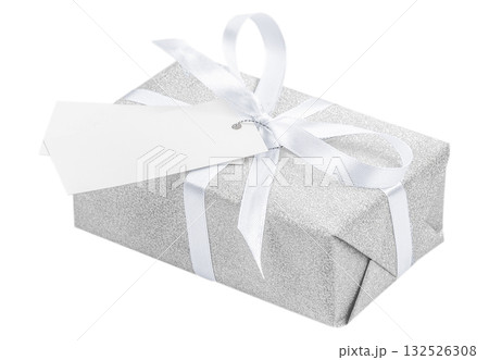 Elegant silver gift box wrapped with a white satin ribbon and blank tag, isolated on white background, symbolizing luxury, celebration, and minimalist holiday style 132526308