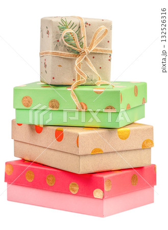 Stack of colorful gift boxes in green, red, and kraft paper with gold polka dots and natural twine ribbon, isolated on white background, symbolizing celebration and eco-friendly packaging 132526316