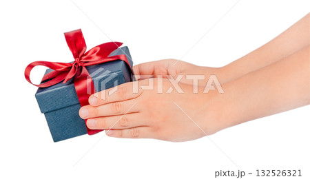 Childs hands holding a small blue gift box wrapped with a red satin ribbon concept of giving, generosity, and holiday spirit, isolated on white background Childs hands holding a small blue gift box wrapped with a red satin ribbon concept of giving, generosity, and holiday spirit, isolated on white background 132526321