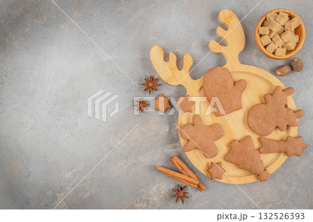 Christmas gingerbread cookies with spices on wooden board on gray background with copy space. top view Christmas gingerbread cookies with spices on wooden board on gray background with copy space. top view 132526393